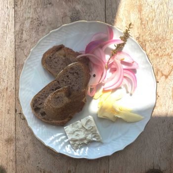 בצל מוחמץ ליד לחם וגבינה